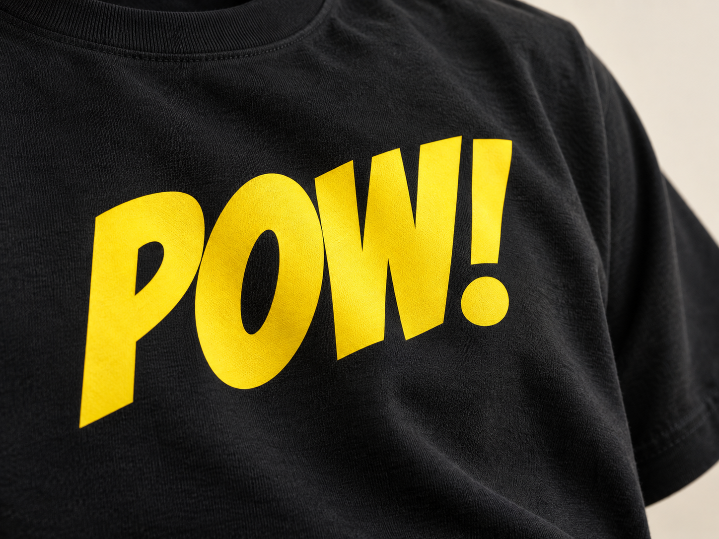 Close-up of a smooth yellow DTF logo print on black fabric