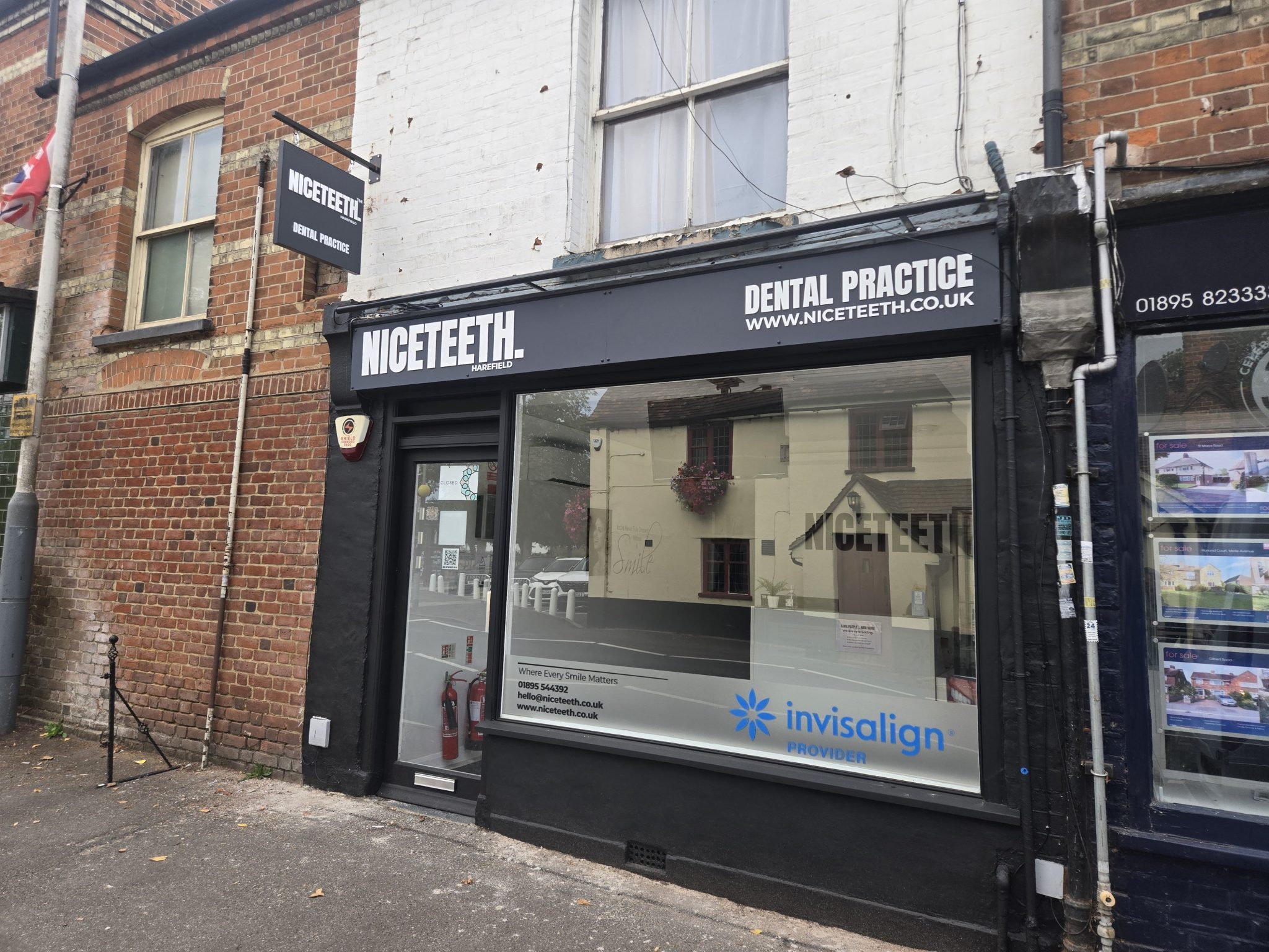 Niceteeth shopfront in Harefield with white fascia lettering, a projecting sign and window graphics