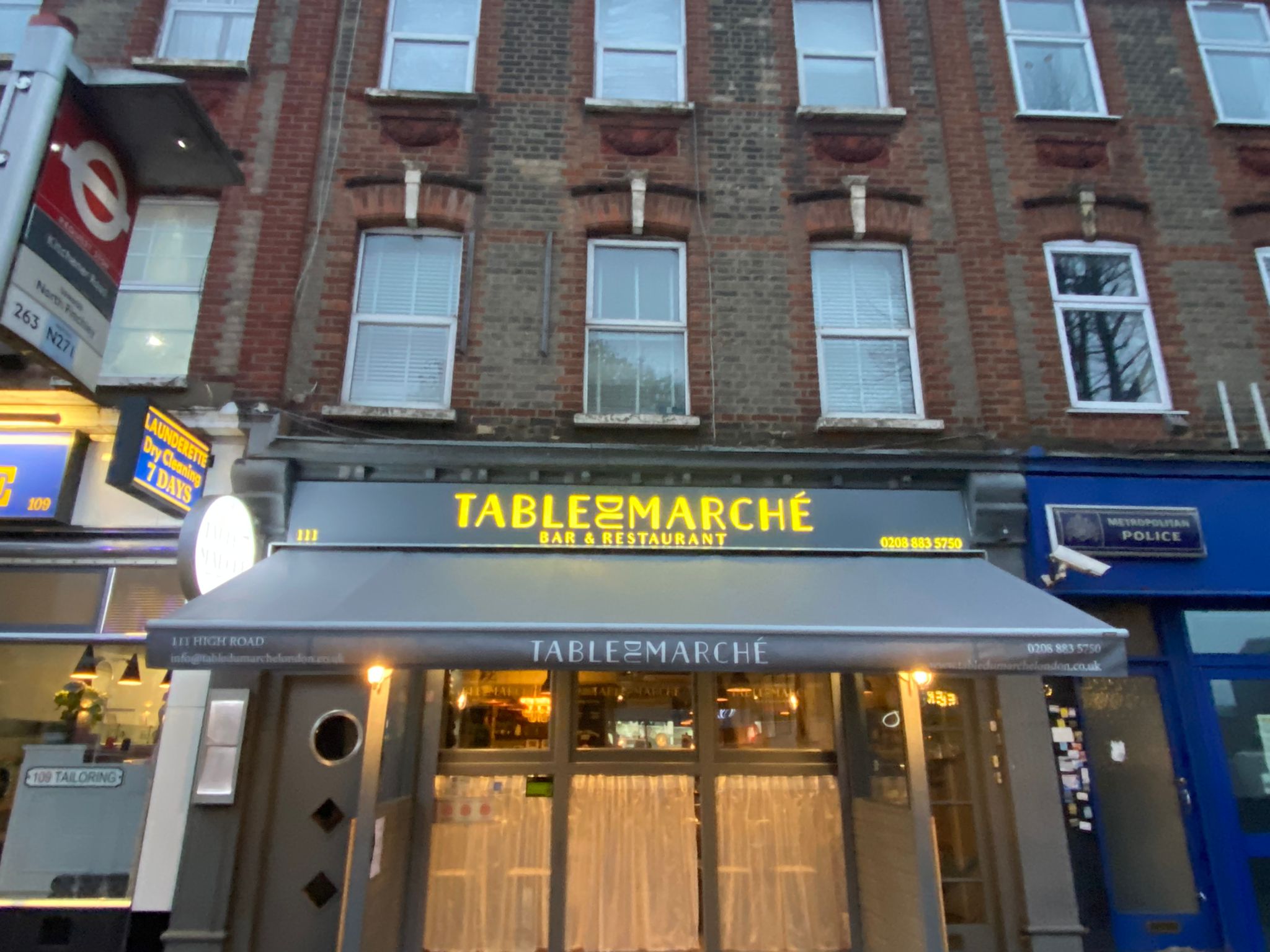 Table du Marché restaurant in North Finchley with illuminated gold lettering above the awning